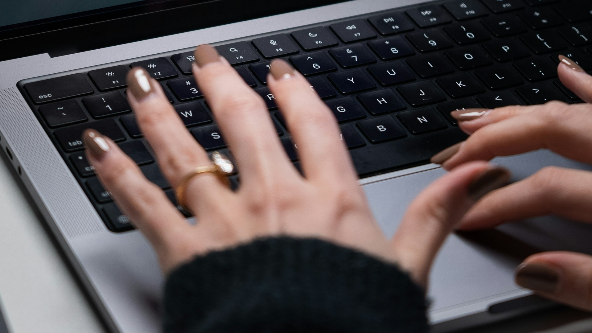 Hands typing on a laptop keyboard